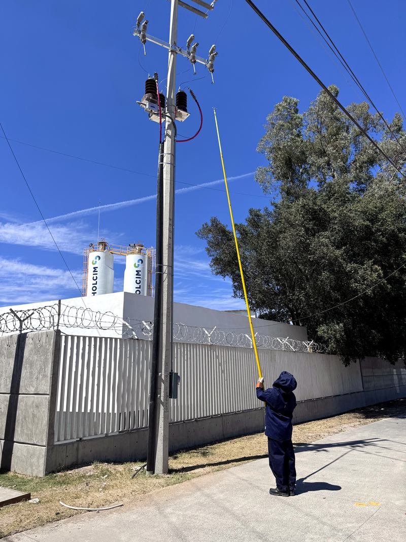 Técnico ZOHMA con pértiga aislada realizando maniobra en línea aérea de media tensión